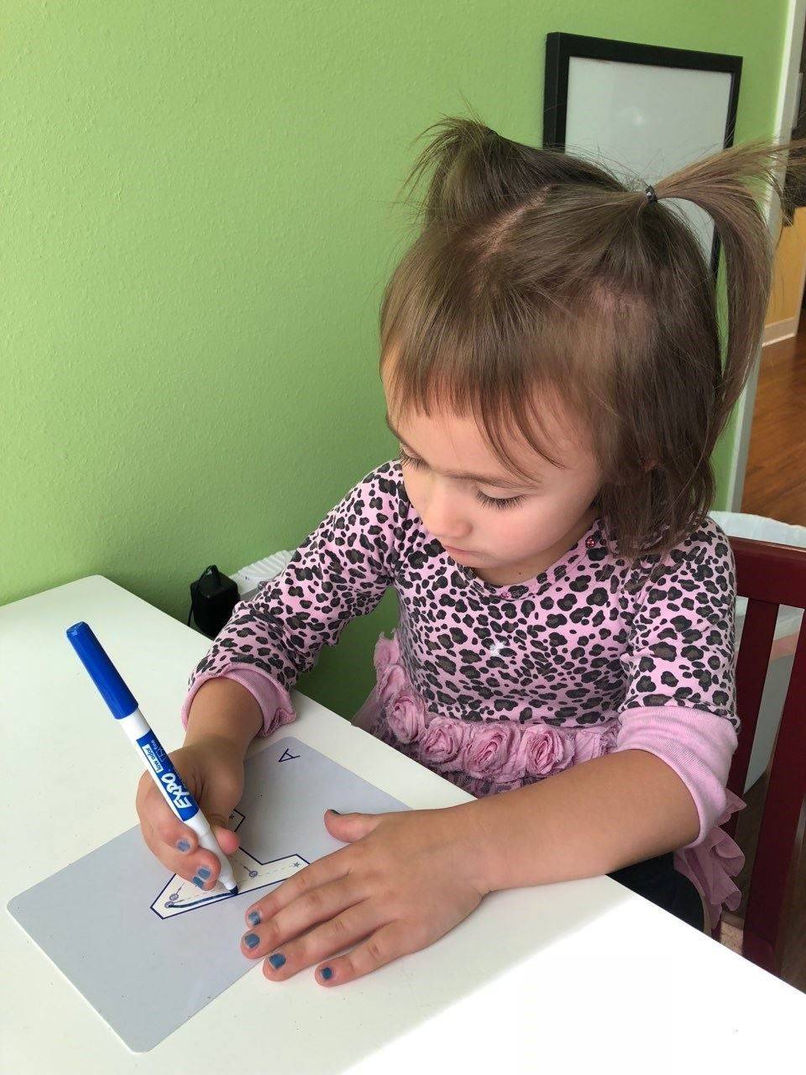 A child practicing fine-motor skills with a marker during occupational therapy