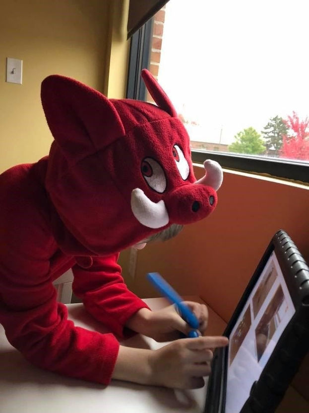 A child using a marker and tablet during a speech therapy activity